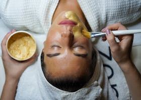 pexels-photo-3212179-3212179 A woman enjoying a gold facial mask for relaxation and skincare at a spa.